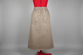 Beige skirt on a red stand against a white door.